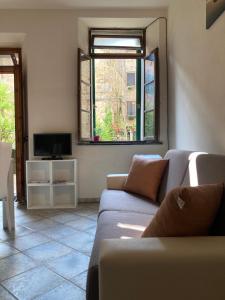 salon z kanapą i telewizorem w obiekcie Great studio apartment in the heart of Chianni w mieście Chianni