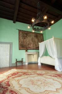 Habitación con cama y pintura en la pared en Villa Il Fedino en San Casciano in Val di Pesa