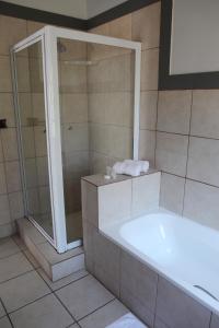 a bathroom with a bath tub and a shower at Villa de Ghaap Guesthouse in Douglas