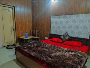 a bedroom with a bed and a table with a chair at SUMAN GUEST HOUSE in Katra