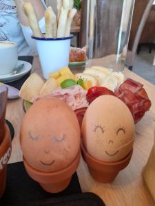 dois ovos com rostos desenhados sobre uma mesa em Obergereuth Hof em San Martino