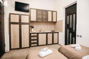a room with two beds and a kitchen with a sink at Nuryan Hotel Yerevan in Yerevan