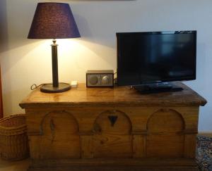 una televisione sopra un tavolo di legno con una lampada di Ferienwohnung Liparis a Bad Birnbach