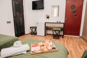 a hotel room with a tray of food on a bed at Nuryan Hotel Yerevan in Yerevan
