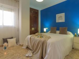 Un dormitorio con una cama grande con una pared azul. en Holidays2Malaga Plaza de Toros Vieja & terrace & optional parking, en Málaga