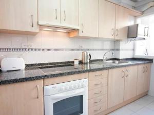 una cocina con armarios blancos y un horno de fogón blanco en Holidays2Malaga Plaza de Toros Vieja & terrace & optional parking, en Málaga