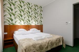 a bedroom with a bed with white towels on it at Hotel Zielony in Poznań