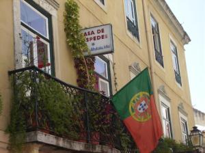 ein Gebäude mit einem Balkon mit einer Flagge darauf in der Unterkunft Dias e Dominguez in Lissabon