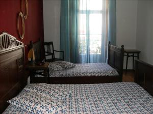 1 Schlafzimmer mit 2 Einzelbetten und einem Fenster in der Unterkunft Dias e Dominguez in Lissabon