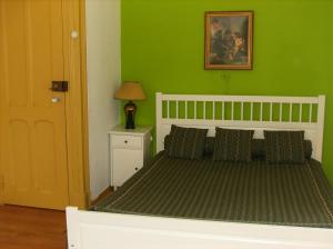 ein Schlafzimmer mit einem Bett mit einer grünen Wand in der Unterkunft Dias e Dominguez in Lissabon
