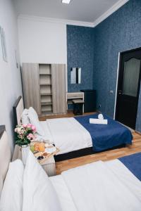 a bedroom with two beds and a table with flowers at Nuryan Hotel Yerevan in Yerevan