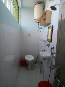 małą łazienkę z toaletą i umywalką w obiekcie MONALISA HOSTEL w mieście Waranasi