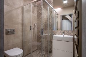 a bathroom with a shower and a toilet and a sink at Aparthotel Rimska 14 in Prague +102 photos