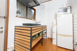a kitchen with a sink and a refrigerator at Leaf in Kamakura