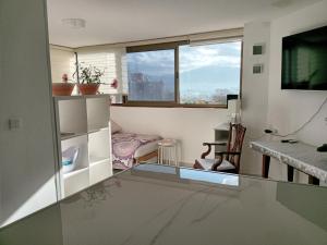 a living room with a table and a window at 123Eilat tzofit in Eilat