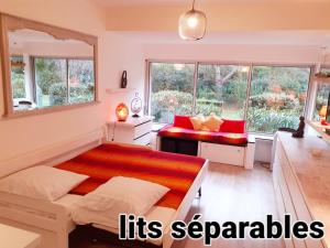 Habitación con 1 cama y 2 ventanas con almohadas rojas. en 3 étoiles au bord de l'eau, en La Seyne-sur-Mer
