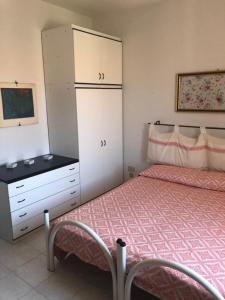 a bedroom with a bed and a dresser and a dresser at Appartamento vicino al mare e al centro in Alghero