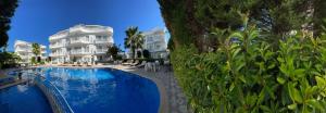 a hotel with a swimming pool in front of a building at BELKA GOLF RESIDENCE Exclusive apt DeluxBELEK in Belek