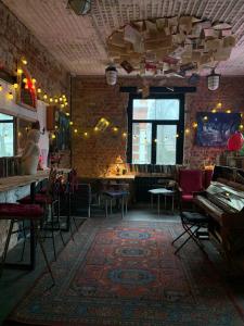 a room with a piano and a bar with chairs at Tolstoy Art-Hostel in Kaliningrad