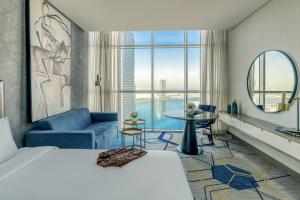 a hotel room with a bed and a large window at Pullman Sharjah in Sharjah