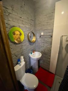a bathroom with a white toilet and a sink at Tolstoy Art-Hostel in Kaliningrad