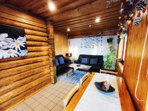 a living room with wooden walls and a table at Sauleskalns in Zaķumuiža