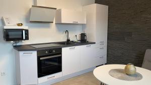 a kitchen with white cabinets and a sink and a table at Casa Wimmer in Allendorf an der Lumda