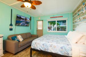 ein Schlafzimmer mit einem Bett und einem Sofa in der Unterkunft Tropic Terrace #9 - Beachfront Rental condo in St Pete Beach