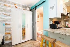 eine Küche mit blauen Wänden und weißen Schränken in der Unterkunft Tropic Terrace #9 - Beachfront Rental condo in St Pete Beach