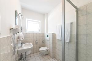 a white toilet sitting next to a bath tub in a bathroom at Hotel Auf d´ Steig in Lindau