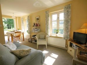 a living room with a couch and a tv at Garden Cottage in Alvescot