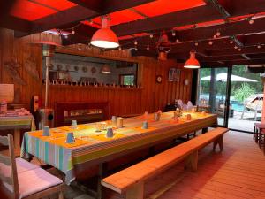 a dining room with a long table in a restaurant at Au Bois Flotté in Hourtin