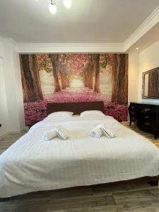 a bedroom with a large bed with two towels on it at Tirana Center Apartment in Tirana