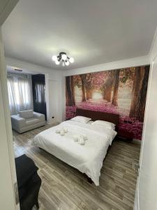 um quarto com uma cama grande e uma pintura na parede em Tirana Center Apartment em Tirana
