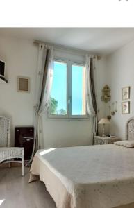 een slaapkamer met een groot bed en een raam bij Appartement très agréable in Fréjus