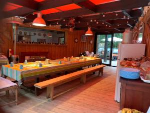 a dining room with a long table with benches at Au Bois Flotté in Hourtin