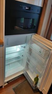 an open refrigerator with a bottle of wine in it at Ferme du Grand-Spinois in Rebecq-Rognon