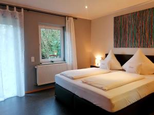 a bedroom with two beds and a window at Weingut Tiliahof in Brauneberg