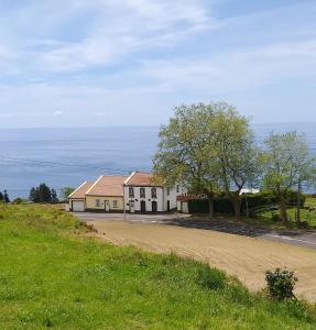 ポヴォアサンにあるCasa da Lomba do Cavaleiroの未舗装路横の丘の上の家