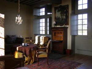 a living room with a table and chairs and a chandelier at Manoir du Plessis au Bois in Vauciennes