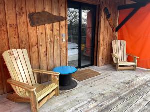 two chairs sitting on a porch of a cabin at Au Bois Flotté in Hourtin