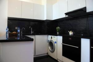 a black and white kitchen with a washing machine at Guest Apartment in Baku
