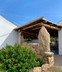 un mur en pierre avec un toit en bois sur un bâtiment dans l'établissement Macciuneddu Country Retreat, à Golfo Aranci