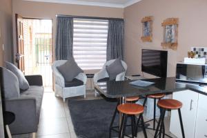 a living room with a desk with a computer and chairs at Shandi Accommodation in eMalahleni