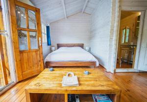 ein kleines Schlafzimmer mit einem Bett und einem Holztisch in der Unterkunft Dahu Wake Park, proche Saint Emilion in Sablons