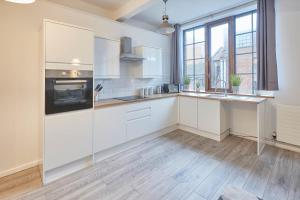 a kitchen with white cabinets and a large window at Host & Stay - Concert Square in Liverpool