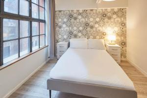a bedroom with a large bed in a room with windows at Host & Stay - Concert Square in Liverpool