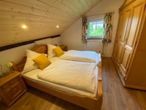 a bedroom with a large bed with yellow pillows at Feriendorf Büchelberg in Windorf