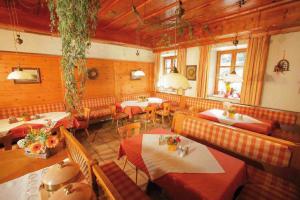 ein Restaurant mit Tischen und Stühlen in einem Zimmer in der Unterkunft Gasthof Huberwirt GmbH in Rosenheim