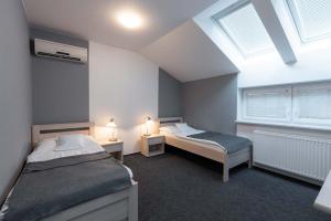 um quarto com 2 camas e 2 janelas em Hotel Lion em Modřice